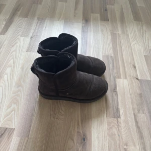 Bruna uggs - Mysiga bruna boots från din sko, med rund tå och platt sula. Skorna har ett fluffigt foder på insidan som håller fötterna varma under kalla dagar. Perfekta för dig som vill ha en enkel och stilren vinterlook.
