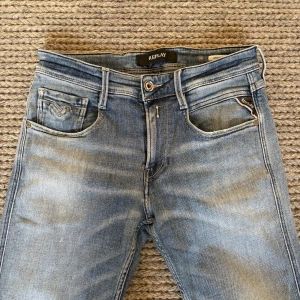 Replay Anbass  - Replay Anbass jeans w 29 L 32 mycket fint skick med en skön fade plus små slitningar vid fickorna som många söker efter!  Längd 100 mc midjemått 37x2 cm men materialet är stretchigt så kan passa lite större. Sitter slim! Nypris 1600