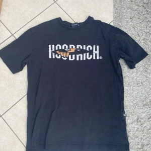 Svart t-shirt från Hoodrich - Svart t-shirt från Hoodrich i bomull med tryck framtill Inga defekter eller fläckar som inte går bort i tvättmaskinen. Säljes då den inte kommer till använding på senaste.