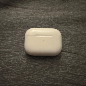 AirPods Pro - Apple AirPods Pro i original laddningsetui. Trådlösa hörlurar med aktiv brusreducering och transparensläge. Fodralet visar mindre tecken på användning men är i mycket bra skick . Hörlurarna fungerar som de ska och levereras rengjorda. Finns kvitto och är köpta på Elgiganten skriv om mer info priset är inte hugget i Sten
