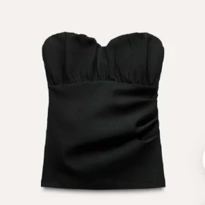 Svart slutsåld tubtopp från Zara - Svart Zara tubtopp från Zara. Köpt från Plick men aldrig använd❤️jag har sytt om så det är dragkedja hela vägen ner, säljer pga att den är för liten! Syns ej att den är omsydd ser ut som ny då min mormor sydde om den❤️