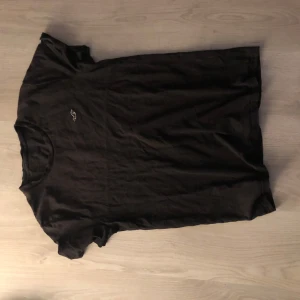 Svart t-shirt från Hollister - Svart t-shirt från Hollister med liten broderad logga på bröstet. Klassisk rund halsringning och korta ärmar. 