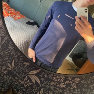 Blå långärmad tröja från Polo Ralph Lauren - Säljer en marinblå långärmad tröja från Polo Ralph Tröjan är i slim fit och storlek S. Tröjan är i gott skick då jag endast använt den ett par gånger.