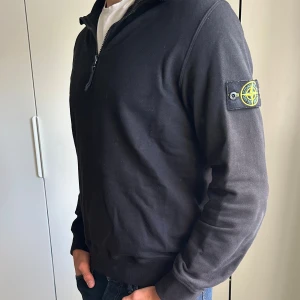 Svart half zip sweatshirt Stone Island - Svart sweatshirt från Stone Island med klassisk patch på ärmen. Tröjan har half zip-dragkedja, ribbade muddar och normal passform. Nypris: 2500kr. Storlek M. Modellen är 190cm, 78kg. Skriv om ni har några som helst funderingar:)