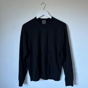 Svart merinoullströja från H&M - En stilren svart tröja från H&M i mjuk merinoull. Klassisk rund halsringning och långärmad modell, perfekt för lager-på-lager. Enkel och clean design som funkar till allt. Snygg passform och skön känsla mot huden. 3R15