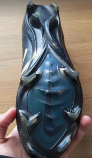 Nike Mercurial ELITE svarta fotbollsskor - Svarta Nike Mercurial fotbollsskor med låg profil och snörning. Skorna har en slimmad design, syntetiskt material och mönstrad yttersula med dobbar för bra grepp på planen. Swoosh-logga på sidan och diskreta detaljer i mörkgrått. Perfekta för dig som vill ha speed och kontroll. Det är ELITE. Snören finns men de är bara inte med i bilden 