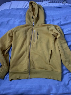Gul Sail racing hoodie - Gul zip hoodie från Sail Racing med dragkedja på bröstet i helt nytt skick, använd ca 2 gånger