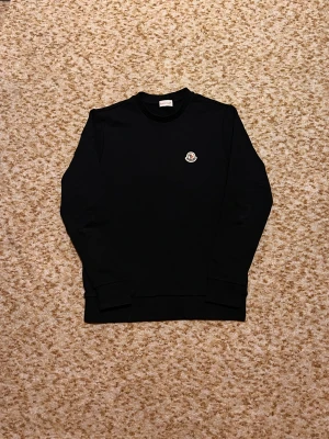 Svart monceer tröja  - Säljer min svarta monceer sweatshirt. Den är i mycket bra skick och aldrig använts. Säljer pågrund av reselling. Den är i storlek S och NFC tagg fungerar. Pris kan diskuteras vid snap affär