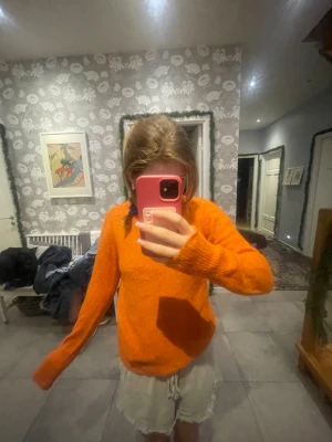 Orange stickad tröja med lång ärm - Säljer en snygg orange stickad tröja med lång ärm och rund hals. Tröjan har en loose passform och är perfekt för dig som gillar färgstarka plagg. Materialet är mjukt och skönt, och den passar dig som vill ha en chill och bekväm stil.