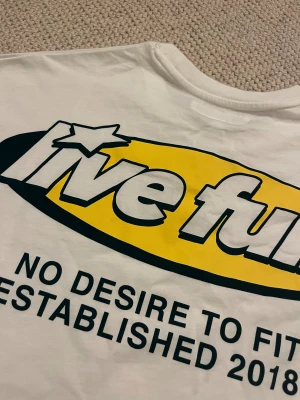 Vit långärmad tröja Live Fully - Lappen slets av men aldrig andvänt och skulle egentligen lämnas tillbaka!!! Vit långärmad tröja från pacific rebuplic  med trycket 'Live Fully' i svart och gult på både bröstet och ryggen. Tröjan har rund hals och är gjord i mjuk bomull. I st XS.