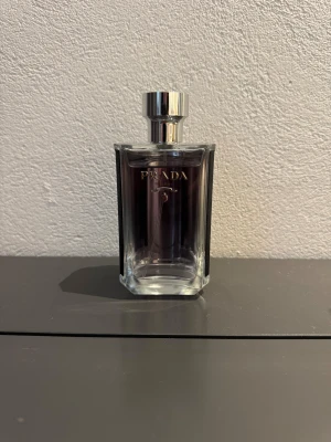 Prada L’homme - Prada L’homme är en ren, elegant och pudrig doft med iris, neroli och trä. Sofistikerad, fräsch och perfekt för både vardag och kontor. Finns som tester i 2 ml, 5 ml och 10 ml. 2 ml kostar 30kr, 5 ml kostar 90kr och 10 ml kostar 150kr.
