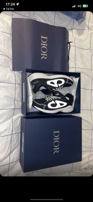 Svarta och vita Dior sneakers - Helt nya o använda!! Säljer ett par snygga Dior sneakers i svart och vitt med chunky vit sula och coola detaljer på sidan. Skorna har snörning och meshpartier för extra komfort. Ikonisk Dior-logga på plösen och boxen medföljer. Perfekt för dig som gillar exklusiva märken och streetstyle.