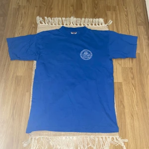 Blå t-shirt med tryck  - Blå t-shirt med vitt tryck i storlek medium