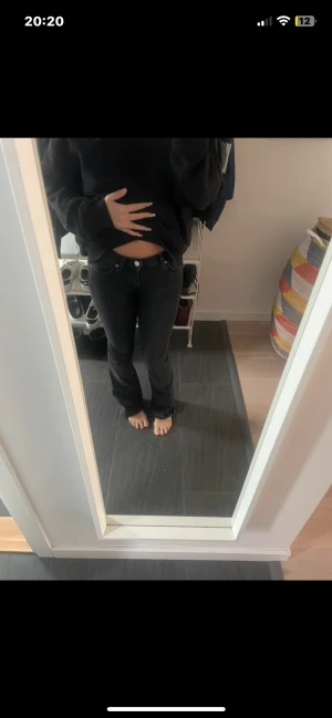 Svarta bootcut jeans - Säljer ett par svarta jeans med bootcut-modell och låg midja. Jeansen har klassisk femficksdesign och är tillverkade i ett stretchigt denimtyg som sitter snyggt över höfterna och låren. Perfekta för dig som gillar en tidlös och clean look.