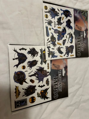 Batman & Spiderman temporära tatueringar - Två ark med temporära tatueringar med Batman- och Spidermanmotiv. Färgglada tryck i blått, svart, rött och gult med olika poser och loggor. Perfekt för att piffa upp din look med superhjältetema. Lätta att applicera och ta bort.  50kr/2st/bild  . 3 år + 