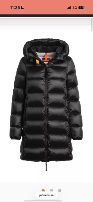 Parajumper Marion - Säljer en svart, lång dunjacka från Parajumpers i modellen Marion med huva och snygga quiltade paneler. Jackan har dragkedja framtill och en cool orange detalj vid halsen. Perfekt för kalla dagar och har en modern, clean look. Jag köpte den för några dagar sedan, har kvitto på den. Den var lite för tajt men butiken vägrade ta tillbaka den då lapparna var av. Den är i storlek 164 i barn vilket motsvarar dam Xs eller 34. Så jackan är alltså helt helt ny och oanvänd.