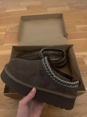 Bruna skor - Säljer ett par bruna skor med platt sula och rund tå. Skorna har ett snyggt broderat mönster runt öppningen och är fodrade med mjuk päls på insidan. Yttermaterialet är mocka. Perfekta för kalla dagar! Stolek 37 MEN skulle säga mer som en mindre 36:or. 