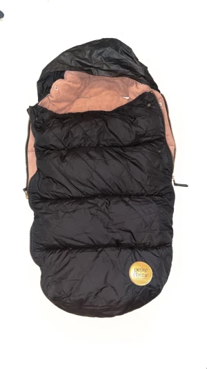 Petite Chérie Åkpåse - Varm och mjuk åkpåse från Petite Chérie i svart och brunt. Passar de flesta barnvagnar, med öppningar för sele. Yttertyg i vattenavvisande material, insida i mjuk fleece. Bra skick, inga synliga defekter eller större slitage.