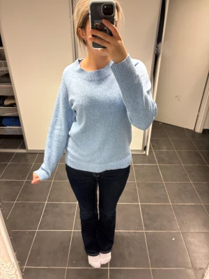Ljusblå stickad tröja - Mysig ljusblå stickad tröja med rund hals och ribbade muddar vid ärmslut och nederkant. Tröjan har en enkel och clean look som är lätt att matcha med jeans eller andra favoritplagg. Perfekt för dig som gillar en chill och stilren vibe.