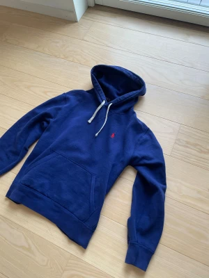 Marinblå hoodie från Polo Ralph Lauren - Säljer en tvär fet mairblp hoodie från Ralph Lauren. Hoodien är väldigt trendig och eftertraktad. Storlek S och passar någonstans runt 170. Vid fler frågor och funderingar är det bara att höra av sig