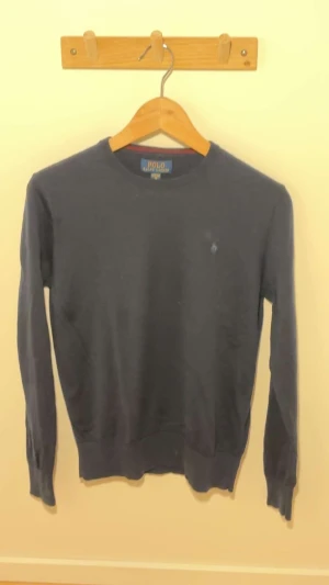 Marinblå Ralph lauren stickad tröja - Fin marinblå stickad Ralph lauren tröja i bra skick. Jag säljer för den har blivit för liten. Storleken är xl barn storlek men passar xs lika bra