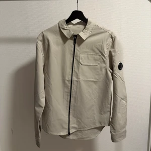 C.p company overshirt - En beige overshirt som är i stolrek S och jättre fin skick. Det kan användas som en overshirt och en jacka.