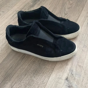 Arigato laceless svarta - Snygga skor i bra skick, skicket visas på bilder då också ett litet hål uppstår, inget som syns på dock! Storlek 41 o bara skorna medföljer! Hör av er