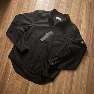 Svart stone island overshirt - Hej säljer en ny stone island overshirt! Den är i storlek M och du får med den i en påse. Skriv om ni har funderingar.