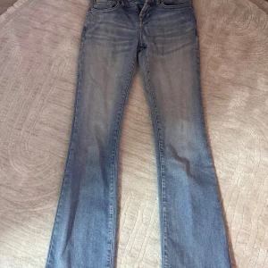 Ljusblå bootcut jeans W24 L32 - Snygga ljusblå jeans från LTB med klassisk bootcut passform. Modellen har fyra fickor, låg midja och subtila slitningar för en chill vibe. Jeansen är tillverkade i mjukt denim och har en stilren look som funkar till sneakers eller boots.