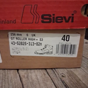 Svarta kängor från Sievi med BOA - Svarta kängor från Sievi med BOA-snörningssystem och robust, mönstrad sula för extra grepp. Ovandelen har detaljer i grått och reflekterande inslag, samt vadderad mesh vid ankeln. Skorna är tillverkade i slitstarkt syntetmaterial och har en sportig, modern look. Ny pris 3500 kr