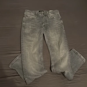 Grå jeans från Jack & Jones - Gråa jeans från Jack & Jones. Tapered storlek 28/32