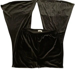 Gothic vida sammet/velvet byxor - Snygga svarta flare byxor från Rokoko i mjuk och glansig sammet. Modellen har riktigt vida ben och resår i midjan för skön passform. 