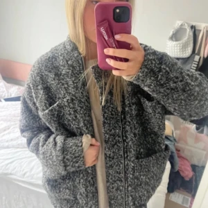 Grå bomberjacka  - Säljer en grå bomberjacka med grov textur och oversized passform. Jackan har stora fickor framtill och stängs med dragkedja. Perfekt för dig som gillar en chill och mysig stil. Jackan är långärmad och har en mörkgrå ton.