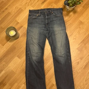 Levi's 507 jeans blå W34 L32 - Säljer ett par klassiska Levi's 507 jeans i snygg mörkblå tvätt med lätt slitning. Modellen har raka ben, fem fickor och ikonisk läderpatch bak i midjan. Perfekt passform och cool vintagekänsla, passar dig som gillar tidlös denim.