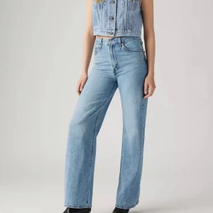 Levi's ljusblå wide jeans - Säljer ett par klassiska jeans i ljusblå denim. Modellen har hög midja, raka ben med wide fit och fem fickor. Jeansen har den ikoniska Levi's-lappen bak och röd etikett på fickan. Perfekt för dig som gillar retro och avslappnad stil. Pris går att diskutera!