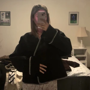 Kappa / tröja  -  svart overshirt med vita kontrastsömmar längs kanterna. Enkel och stilren design som funkar till många outfits. 