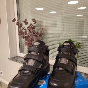 Svarta vinterkängor från Chriss, stl 42 passar 43-44 - Svarta kängor från Chriss i storlek 42, tillverkade i Italien. Skorna har robust sula från Davos, tre kardborreband, grå mesh-detaljer och fodrad insida för extra värme. Perfekta för kalla dagar och outdoor-äventyr.