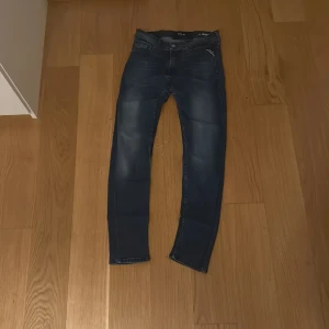 Replay Jondrill  jeans blå - Säljer ett par Replay Jondrill jeans i mörkblå tvätt med snygga slitningar. Modellen är skinny med smal passform och klassisk femficksdesign. Jeansen har dragkedja och knapp framtill, samt Replay-logga på fickan och bak vid linningen. Enda defekten är att en lapp har gått sönder allt annat är felfritt Pris kan diskuteras😄