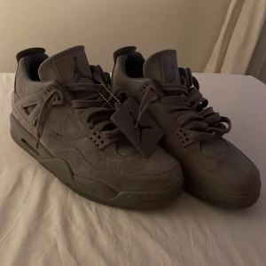 Nike Air Jordan 4, grå mocka - Nike Air Jordan 4 sneakers i grå mocka med unika detaljer på hälen. Lyxig känsla med mjukt material och snygga sömmar, perfekt för dig som vill sticka ut med limited edition sneakers. Nästan oanvända. 
