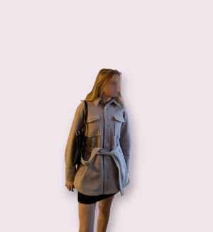 Ljusrosa/ beige kappa i wool blend!🌸🍁🍁 - Säljer en beige overshirt från BikBok i ullblandning. Jackan har stora bröstfickor, knappar framtill och ett snyggt bälte i midjan. Perfekt för lager-på-lager och har en chill, loose passform med klassisk krage och långärmade ärmar! ☺️☺️