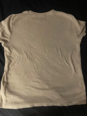 En Beasch T-shirt av moka  - Denna t-shirt från lyle and scott är otroligt skőn, jag säljer denna tröja för att den är för liten och den går att använda när och var som helst.