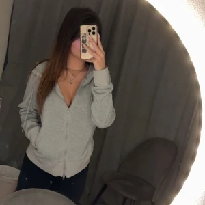 Grå hoodie med dragkedja - Säljer en grå hoodie med dragkedja ”i storlek L” från Shein, passar däremot mig som bär storlek S.