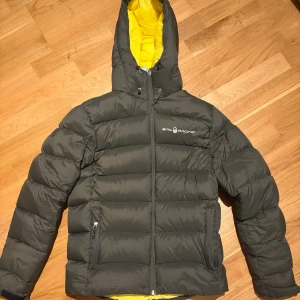 Mörkgrön Sail Racing pufferjacka - I fint skick och de enda defekter är de på bild.