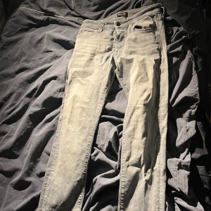 Ljusgrå jeans från Jack & Jones - Säljer ett par ljusgrå jeans från Jack & Jones med klassisk femficksdesign och snyggt läderpatch bak. Jeansen har en slim passform och raka ben, tillverkade i mjukt jeanstyg som sitter skönt hela dagen. Skriv vid minsta fundering!