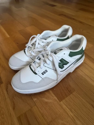 New Balance 550 vita och gröna sneakers - Säljer ett par New Balance 550 sneakers i vitt och grönt med bruna gummisulor. Skornar har endast provats på och är oanvända. Nypris ca 1700 kr (kolla på andra modeller på new balances webbsida). 