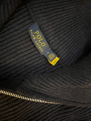 Marin blå stickad kofta från Polo Ralph Lauren - Det Helt ny och superpopular troja! Aldrig använts, i nyskick. Trojan ar tjock, varm och perfekt for vintern, bäde for en fin och bekvam look. Trojan ar unisex och passar bra for bäde kvinnor och man. Säljer den pä grund av storleken. Den är i storlek M. Passar dig som är ungefär 170-190 cm lăng och vager 65-85kg. För dig som söker julklapp är denna tröja perfekt! & Hör gärna av dig om du har nagra fragor eller funderingar!