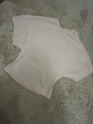 Ljusrosa t-shirt från Nelly XS - Säljer en ljusrosa t-shirt från Nelly i storlek XS. T-shirten har en loose passform och är tillverkad i mjuk bomull. Den är enkel och stilren utan mönster eller detaljer, med klassisk rund hals och korta ärmar. Perfekt för dig som gillar basic och comfy vibes.