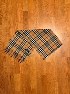 Beige Burberry halsduk - Säljer en beige halsduk från Burberry. Halsduken är gjord i lamull och är i gott skick. Var inte rädd för frågor. Pris diskuteras inte!