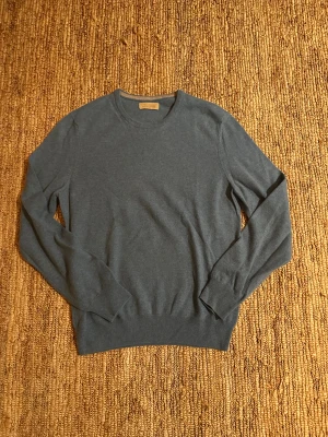 Blå kashmirtröja från Falconeri - Snygg blå tröja från Falconeri i 100% kashmir. Rund halsringning och ribbade muddar vid ärmslut och nederkant. Perfekt för dig som gillar mjuka och lyxiga material. Enkel design som funkar till många olika stilar.