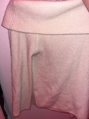 Offshoulder stickad tröja från H&M - Säljer en ljusbeige stickad offshoulder-tröja från H&M i storlek S. Tröjan har en bred, nedvikt krage och är långärmad. Perfekt för dig som gillar en chill och snygg stil med lite extra edge. Materialet är mjukt och skönt stickat.